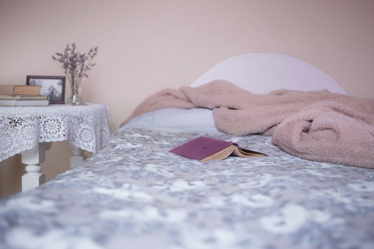 bed with a book and a cover